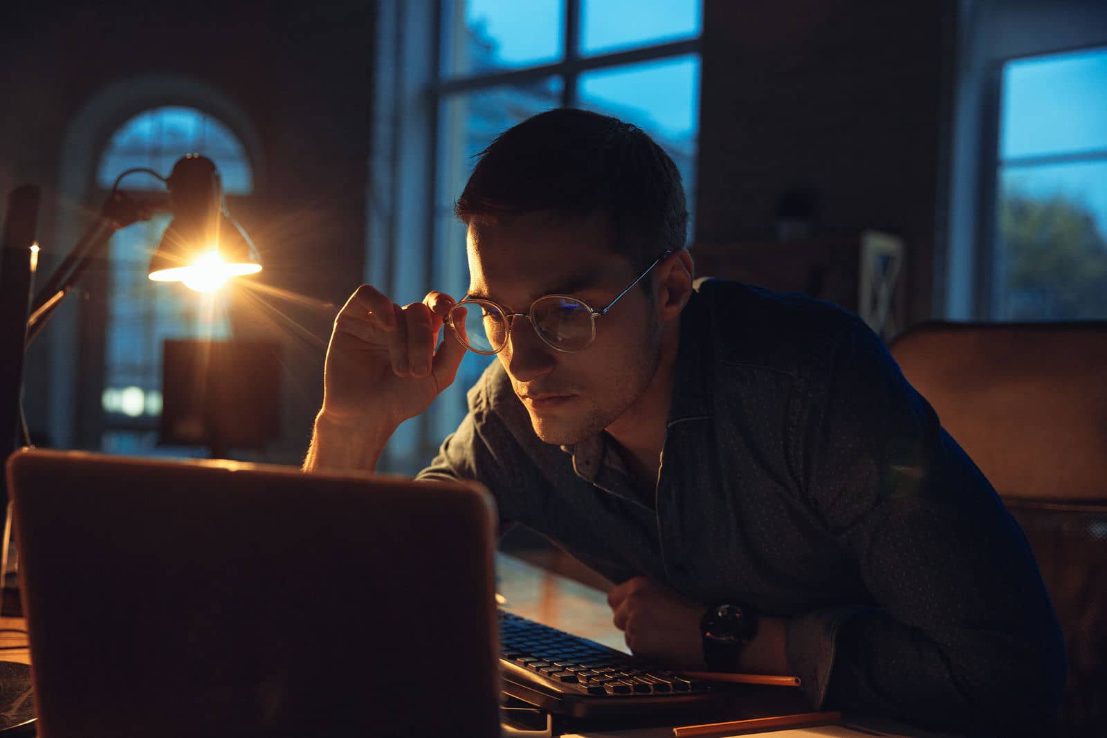 Ragazzo in ufficio che guarda un corso di formazione al PC di sera