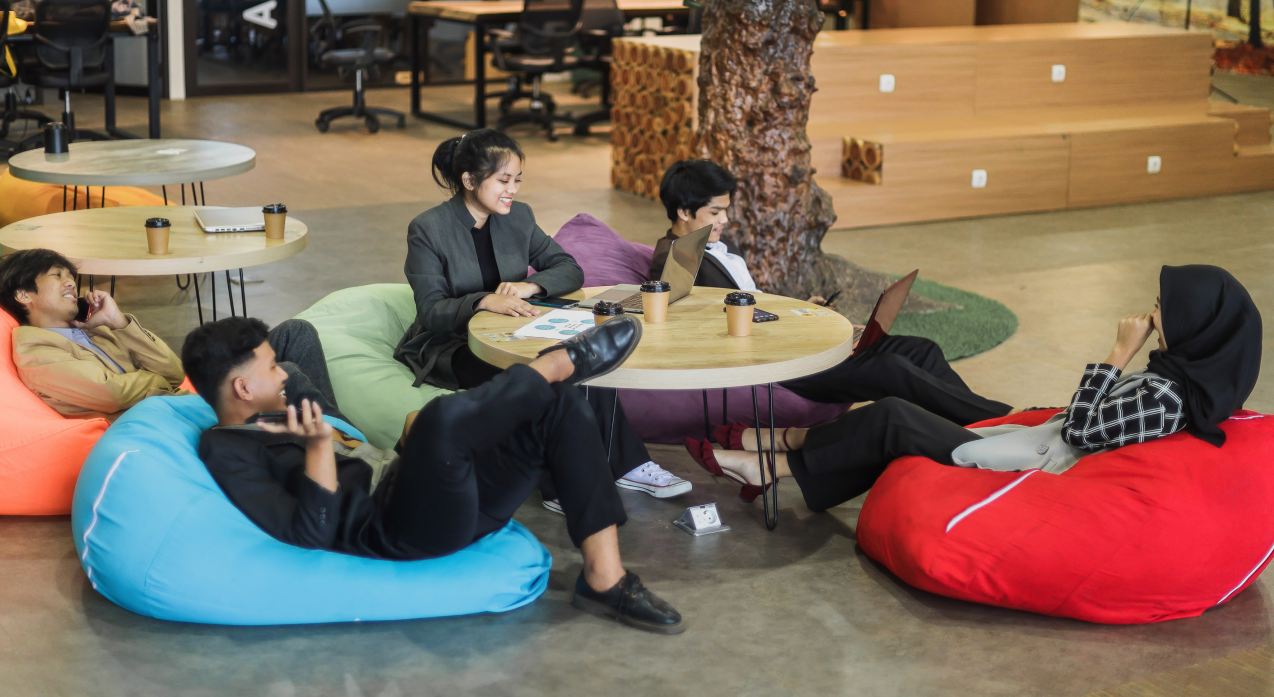 5 ragazzi che fanno formazione seduti su dei divanetti in un openspace